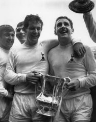 Skipper Dave Mackay holds the trophy, assisted by Alan Mullery, with Terry Venables and Pat Jennings looking on